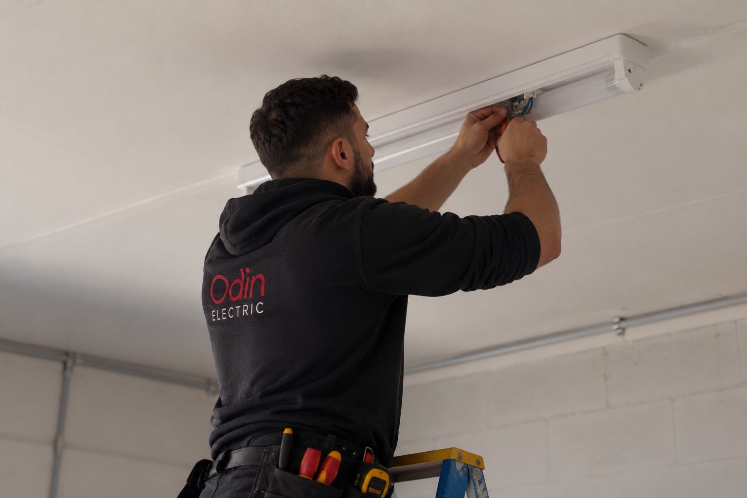 Yazen from Odin Electric fitting a batten light to a garage ceiling